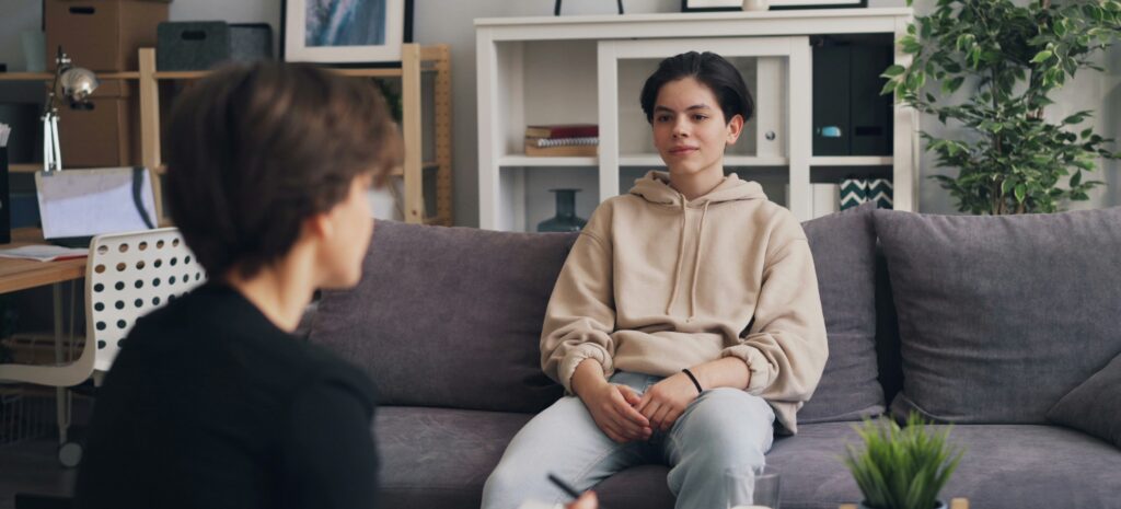 Teen talking with a mental health professional in a supportive treatment setting