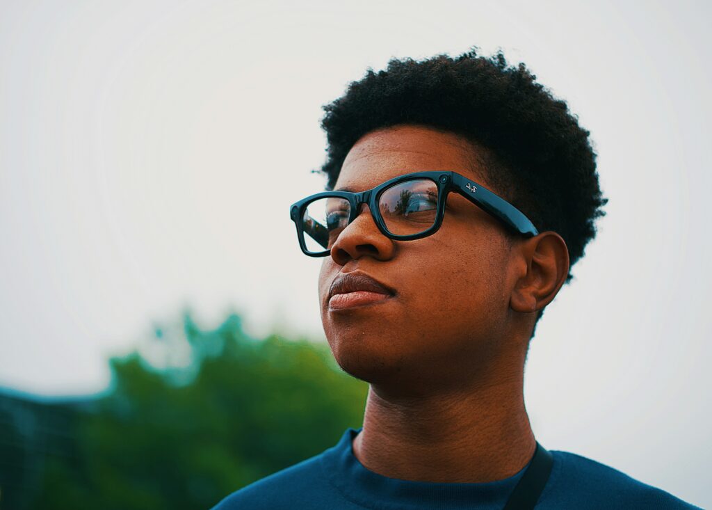 Teen wearing glasses outdoors, representing signs of autism in teenagers